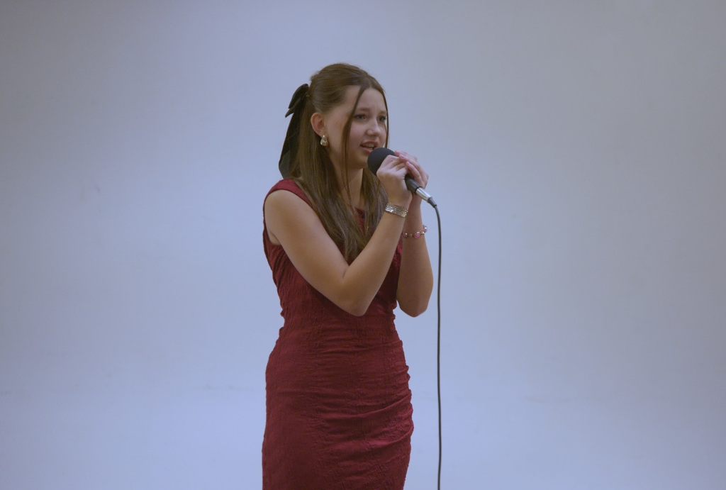 – Dziewczynka w wieku około 13 lat, śpiewająca do mikrofonu na białym tle 