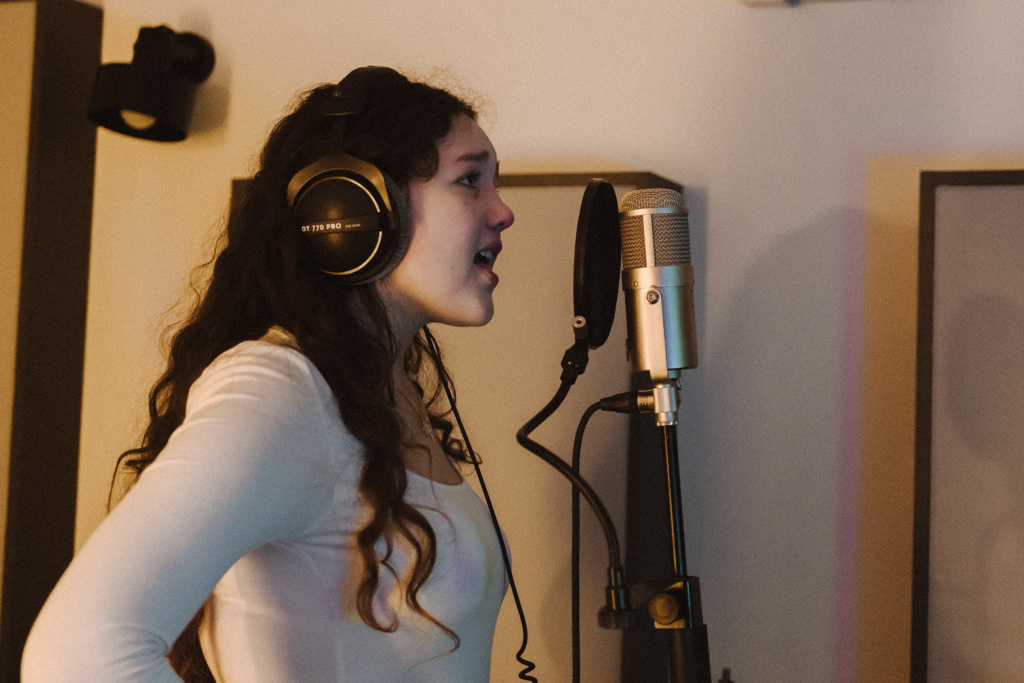 Studio nagraniowe, dziewczyna śpiewająca do mikrofonu 