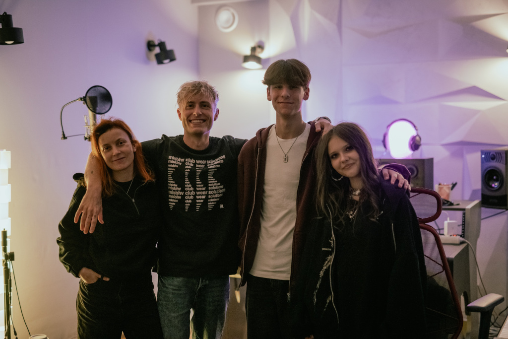 Studio nagraniowe, na pierwszym planie od lewej kobieta producent muzyczny, chłopiec, dziewczynka  